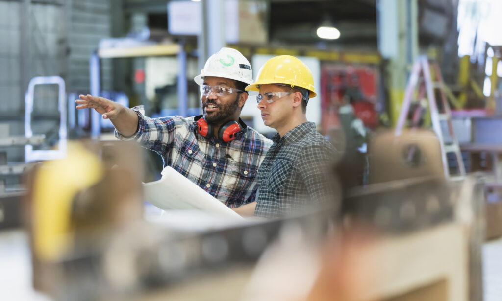 Multi-ethnic workers talking in metal fabrication plant