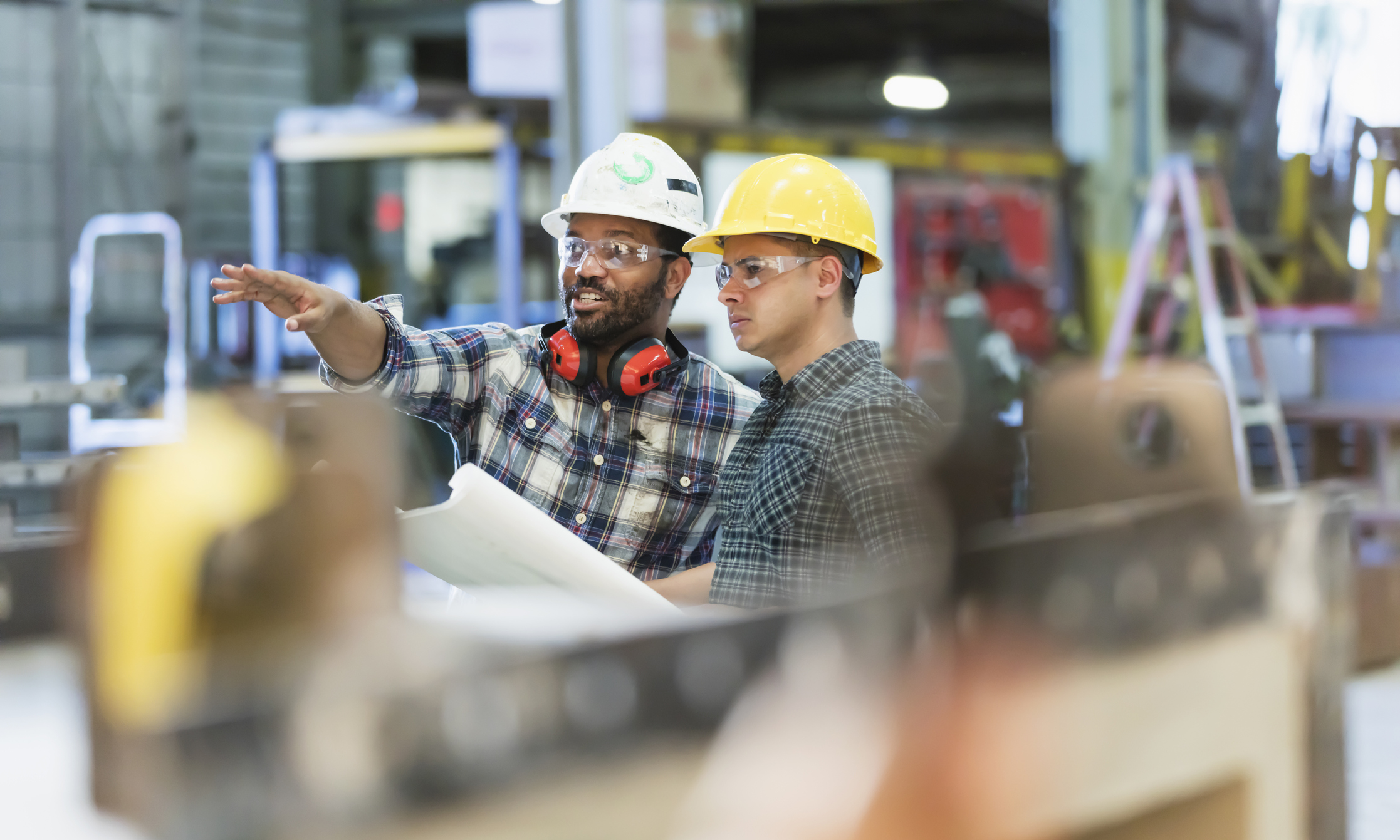 Multi-ethnic workers talking in metal fabrication plant