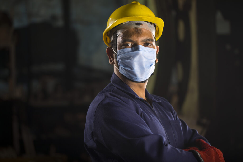 Mechanic wearing protective face mask looking at camera