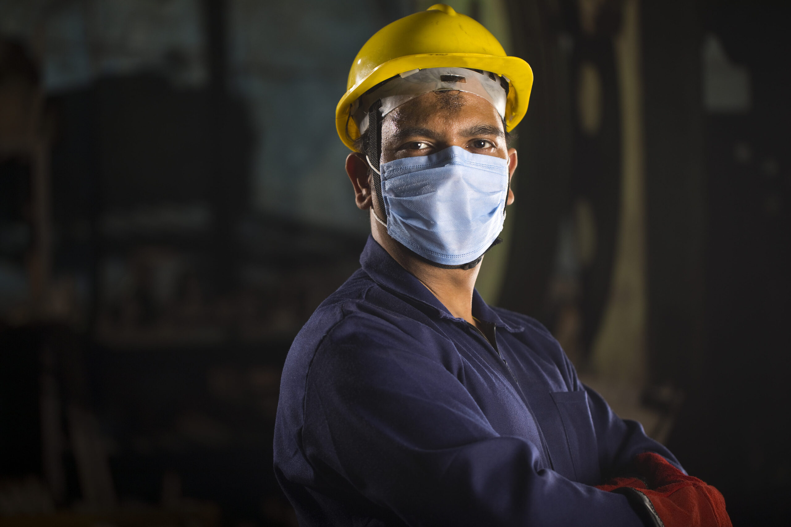 Mechanic wearing protective face mask looking at camera
