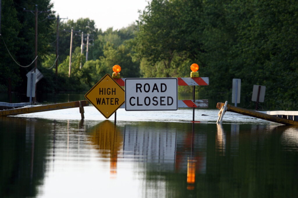 A road closure signage as water covers the road