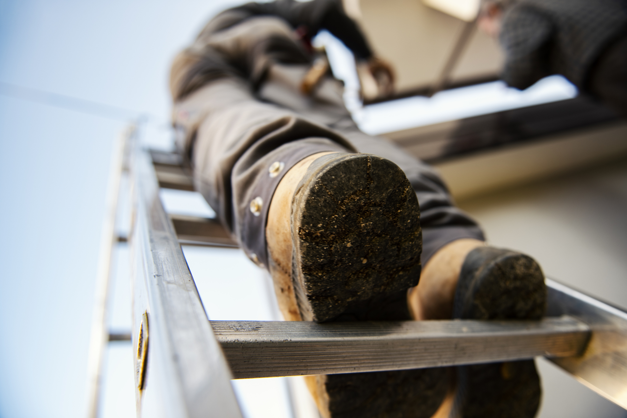 Worker on roof installing metal tile