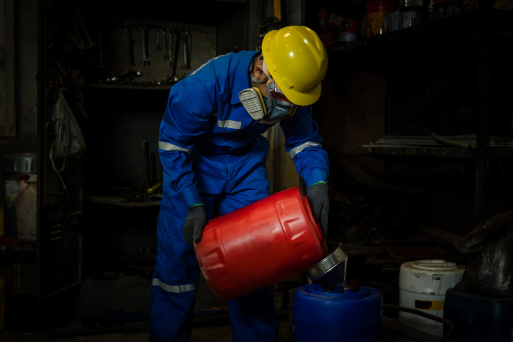 A Worker industry wearing safety uniform ,black gloves and gas mask under checking chemical tank in industry factory work