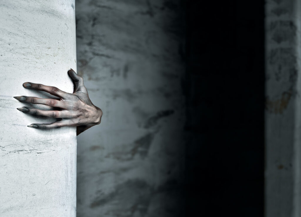 A Scary Hand Reaches out from Behind a Wall