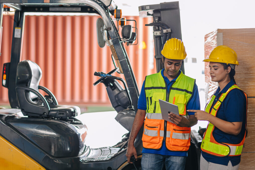 Two people talking in front of a forklift with a clipboard - KPA EHS Safety Software Basic Forklift Training