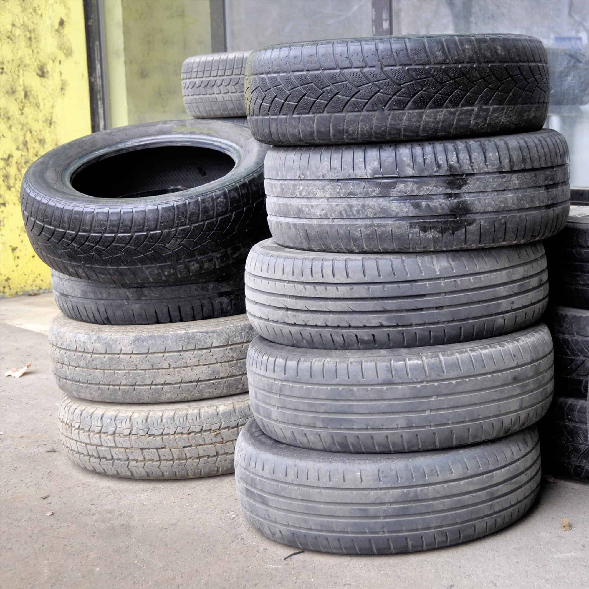 pile of old used car tires arranged in high piles.