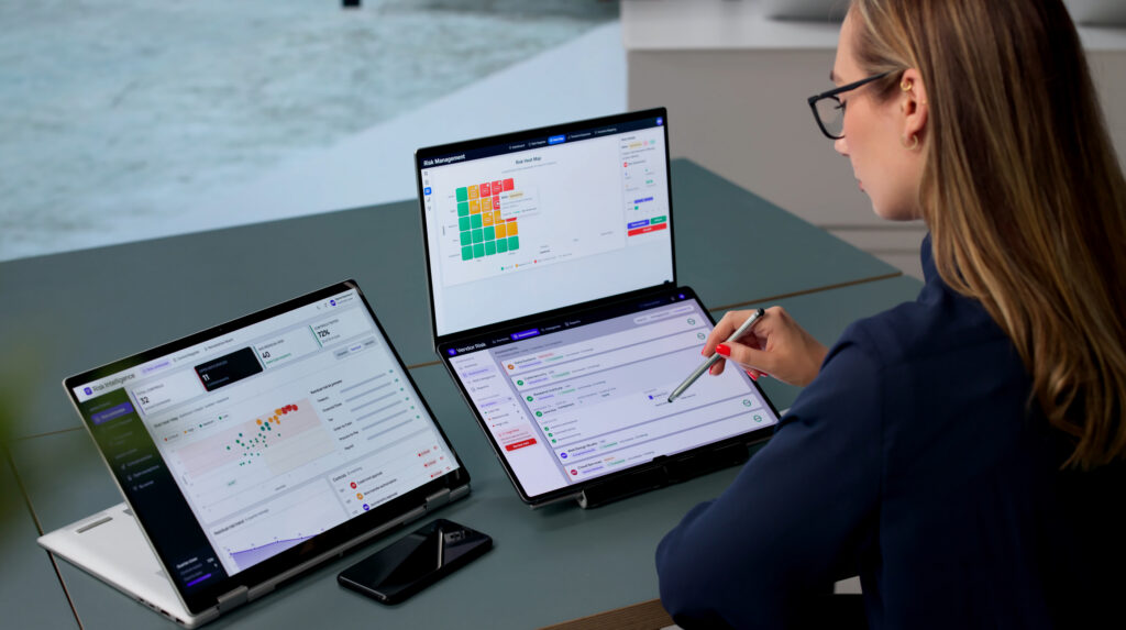 Woman Reviews Compliance Data On Dual Screens For Operational Risk Management Tasks.