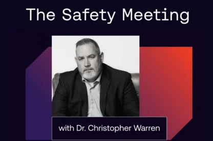 A man in a suit sits for a portrait. Text above reads “The Safety Meeting” and below reads “with Dr. Christopher Warren.” The background features dark and red geometric shapes.
